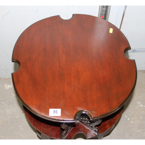 86 - An antique style mahogany revolving bookcase table with fretwork panels