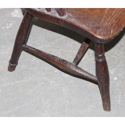 91 - A 19th century elm seated wheel back farmhouse Windsor armchair, stamped rail to reverse