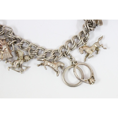 1152 - A silver charm bracelet and 12 charms, approx 44.75g gross