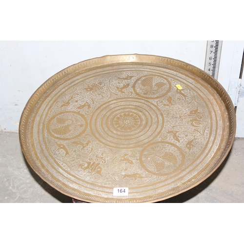 164 - A copper tray topped table with folding wooden base, the top approx 64cm in diameter