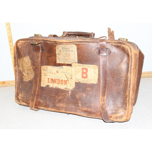 206 - A large early 20th century leather travelling case or luggage bag with labels