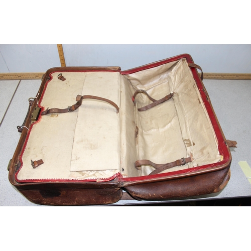 206 - A large early 20th century leather travelling case or luggage bag with labels