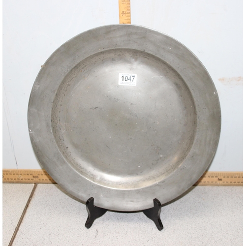 1047 - A large antique pewter charger, 19th century or earlier, approx 42cm in diameter, some impressed mar... 