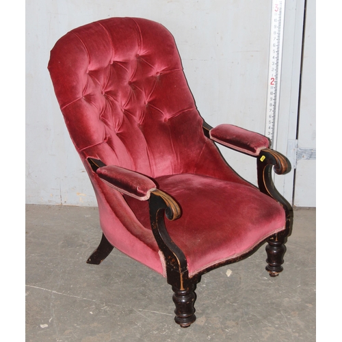 173 - An antique pink button backed armchair with ebonised frame