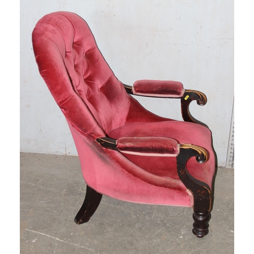 173 - An antique pink button backed armchair with ebonised frame