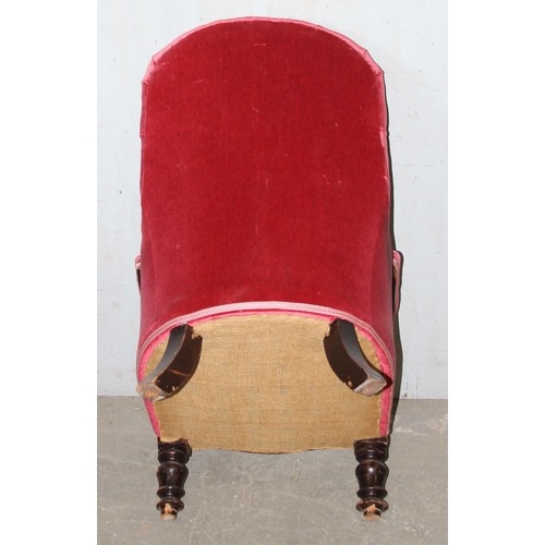 173 - An antique pink button backed armchair with ebonised frame