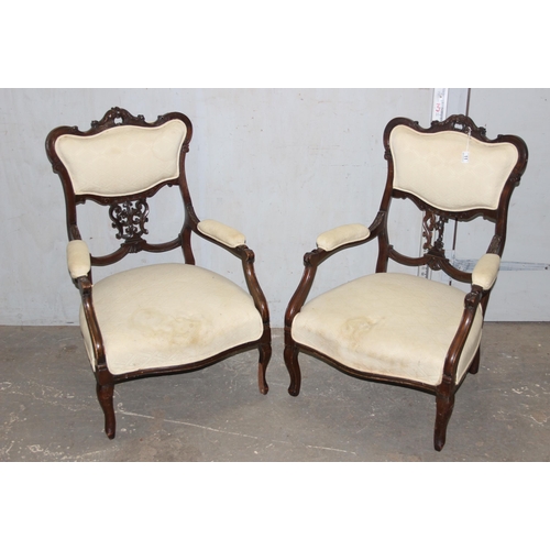 27 - A pair of Victorian armchairs with carved details and stuffed seats and backs