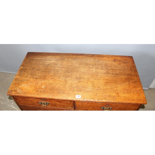 10 - An antique oak 2 over 2 chest of drawers with brass handles and bracket feet, approx 110cm wide