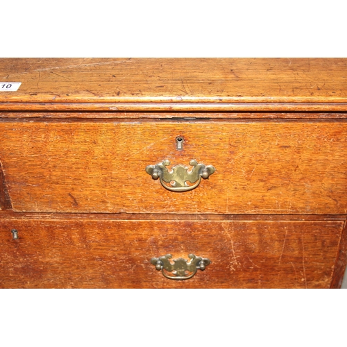 10 - An antique oak 2 over 2 chest of drawers with brass handles and bracket feet, approx 110cm wide