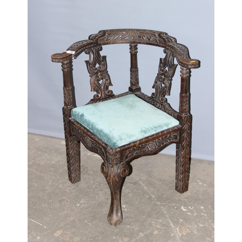 35 - A highly decorative antique carved oak corner chair