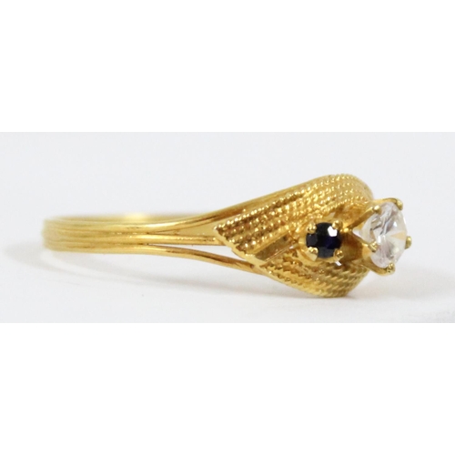 1101 - An 18ct gold ring with retro setting, central white stone flanked by 2 small blue sapphires, approx ... 