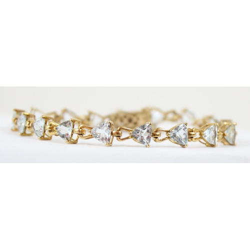 1112 - An Italian 9ct gold retro style tennis bracelet set with triangular shaped white/ light blue stones,... 