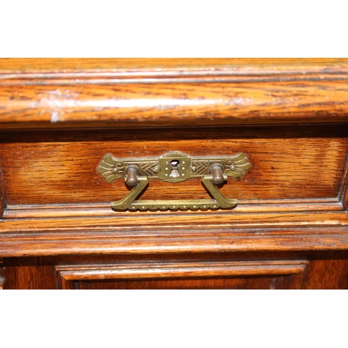 42 - An early 20th century oak pedestal desk with brass handles, approx 140cm wide