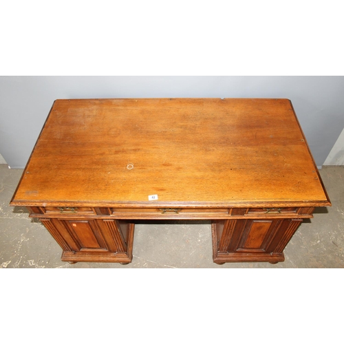 42 - An early 20th century oak pedestal desk with brass handles, approx 140cm wide