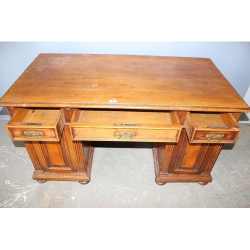 42 - An early 20th century oak pedestal desk with brass handles, approx 140cm wide