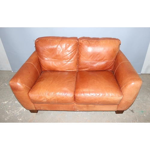 60 - An Italian tan leather 2 seater sofa with footstool by Sofitalia International