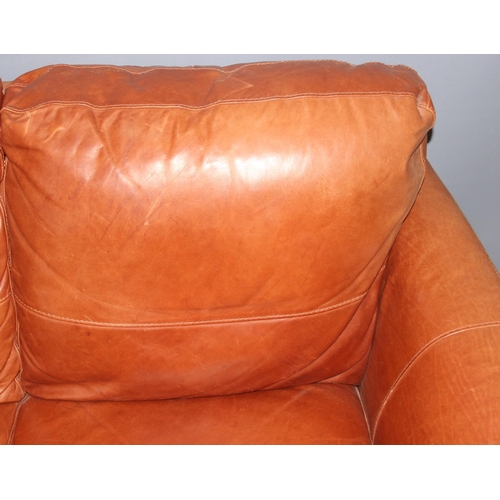 60 - An Italian tan leather 2 seater sofa with footstool by Sofitalia International