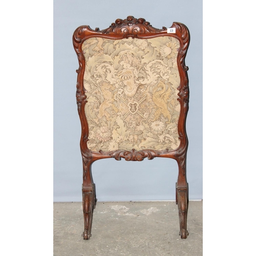 69 - An antique carved walnut fire screen with needlework panel, approx 110cm tall