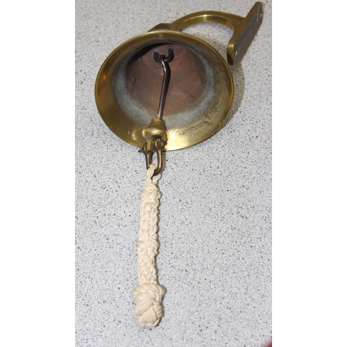 1786 - A brass wall hanging bell with rope handle