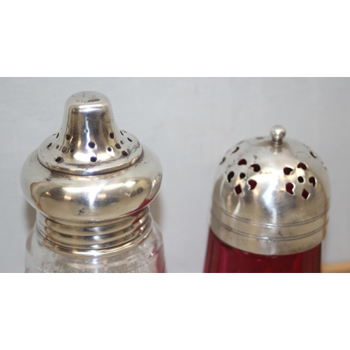 1020 - A silver topped and cut glass sugar shaker, London 1922 and a silver plated and cranberry glass shak... 