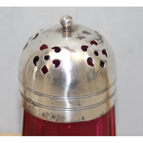 1020 - A silver topped and cut glass sugar shaker, London 1922 and a silver plated and cranberry glass shak... 