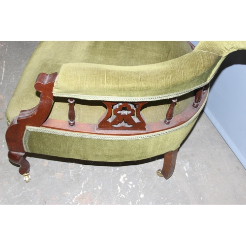 77 - Pair of green velvet vintage low seated tub chairs with brass castors