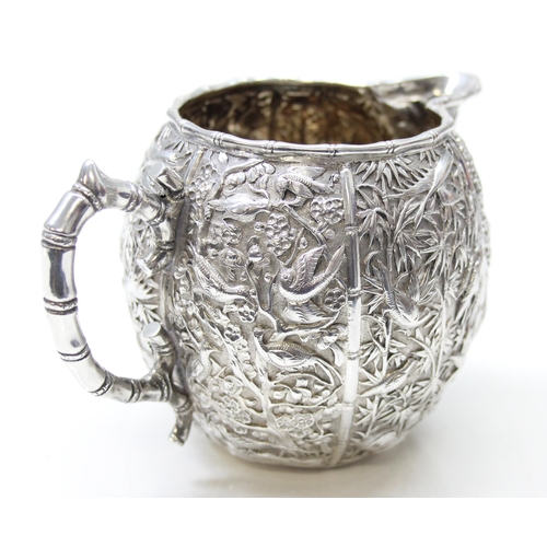 1048 - Chinese export silver milk or cream jug by Wang Hing, early 20th century, profusely decorated with b... 