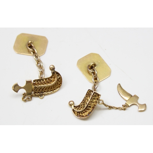 1144 - A pair of high carat gold Middle Eastern cufflinks formed as a pair of Jambiya daggers with filigree... 