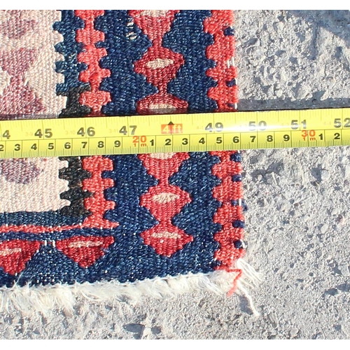 209 - A vintage Kilim flat weave rug of red and blue ground, approx 260cm x 126cm