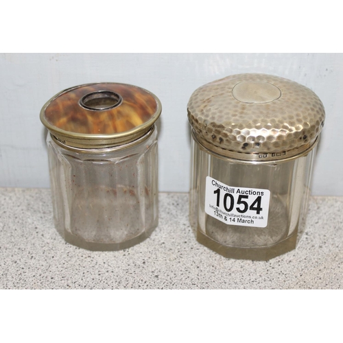 1054 - A silver topped and cut glass jar with planished finish, Birmingham 1901 and another faux tortoisesh... 