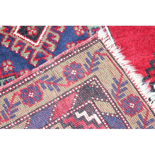 221 - A vintage hand made rug, possibly Turkish, with red and green ground, approx 195cm x 100cm