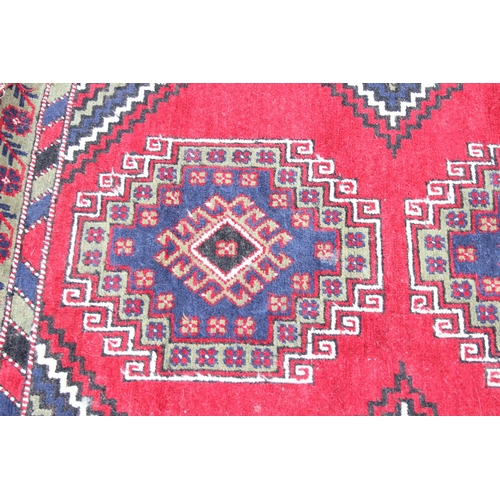 221 - A vintage hand made rug, possibly Turkish, with red and green ground, approx 195cm x 100cm