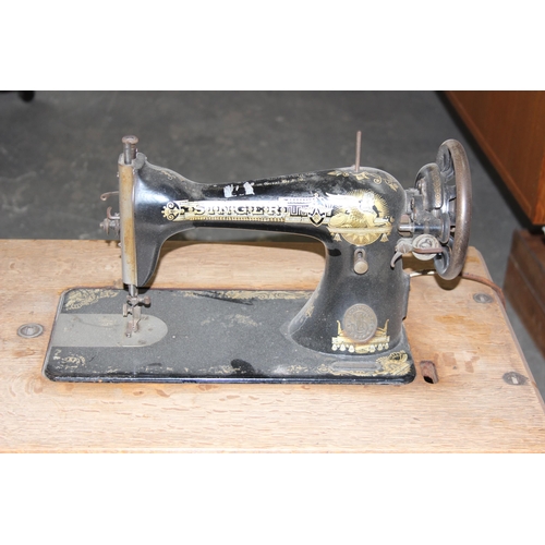 139 - A vintage Singer sewing machine table with machine and cast iron base