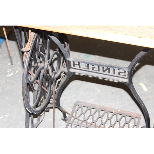 139 - A vintage Singer sewing machine table with machine and cast iron base