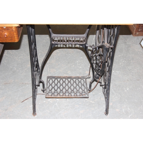 139 - A vintage Singer sewing machine table with machine and cast iron base