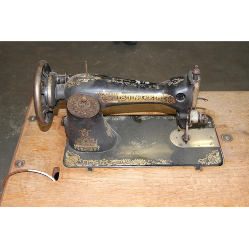 139 - A vintage Singer sewing machine table with machine and cast iron base