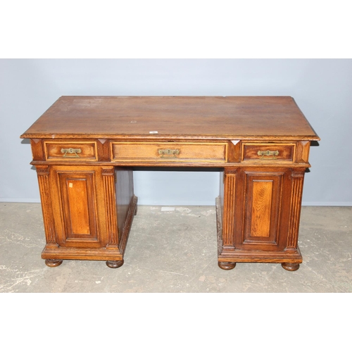 20 - An early 20th century oak pedestal desk with brass handles, approx 140cm wide