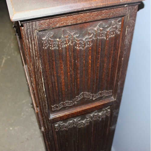 22 - A heavily carved 16th century style oak aumbry or livery cupboard, carved with the Tudor rose and a ... 