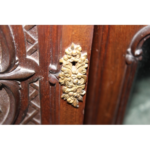 23 - A late 19th or early 20th century carved wooden sideboard by Maple & Co of London & Paris, 2 cupboar... 