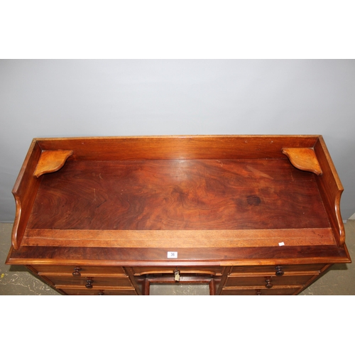 36 - A late 19th century mahogany kneehole desk with 7 drawers and a single cupboard with back rail and c... 