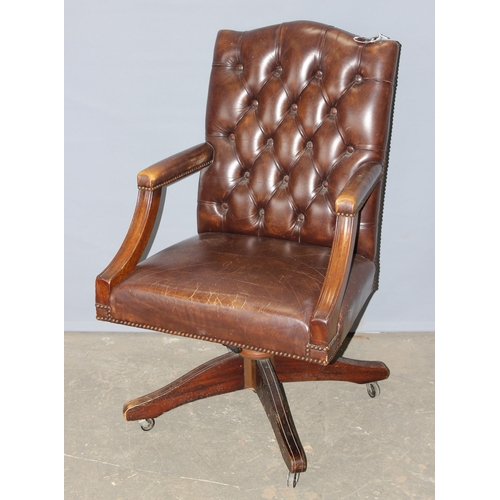 37 - An antique style Chesterfield button backed Captain's or office desk chair, in dark brown leather or... 