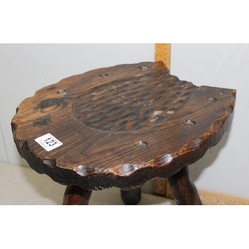 123 - An interesting stained pine 3 legged milking stool with carved horseshoe detail to the seat