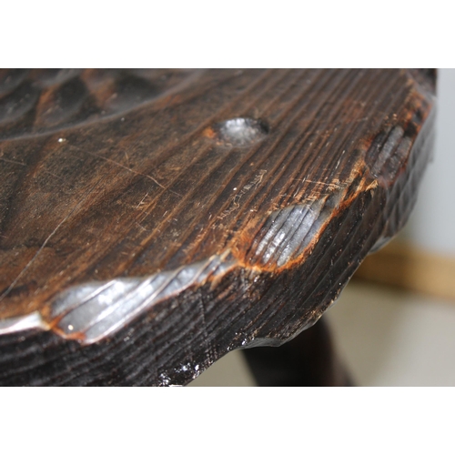 123 - An interesting stained pine 3 legged milking stool with carved horseshoe detail to the seat