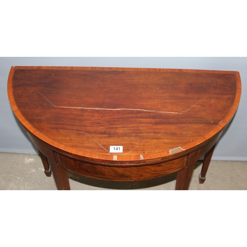 141 - Antique mahogany demi-lune folding card table with spade feet