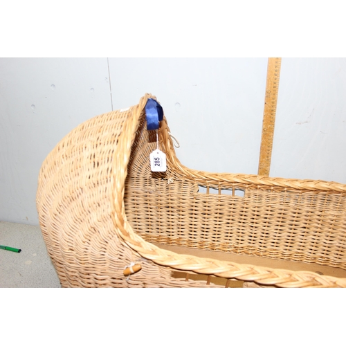 285 - A vintage wicker crib and a number of other wicker baskets