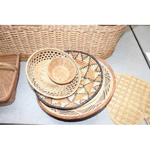 285 - A vintage wicker crib and a number of other wicker baskets