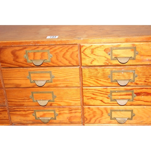 144 - A mid-century bank of pine fronted filing drawers, 15 drawers in 5x3 formation, no makers marks, app... 