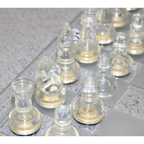 1521 - Frosted bevelled glass chess board with matching clear and frosted glass Chess pieces.