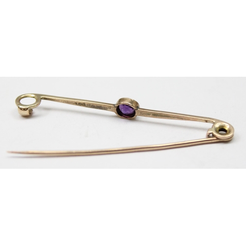 1111 - 9ct gold brooch set with purple stone, approx 1.17g gross, approx 4cm