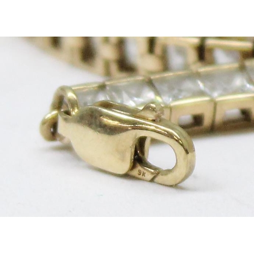 1114 - 9ct gold tennis bracelet set with square cut white stones, gross weight approx 11.23g, 20cm